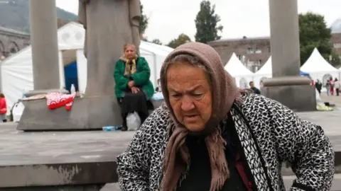 An ethnic Armenian woman from Nagorno-Karabakh walks near the registration and distribution centre in Goris