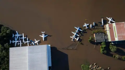 EPA Aerial view showing planes on a flooded runway at Salgado Filho International Airport in Porto Alegre, Brazil, on 06 May 2024. Floods caused by heavy rains in southern Brazil have caused at least 86 deaths and left 134 missing, according to the latest figures released 06 May by regional authorities.