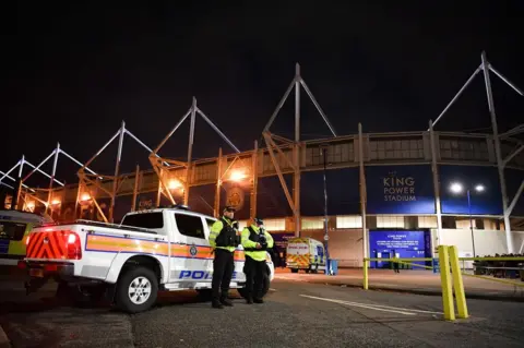 AFP Police officers secure the area outside Leicester City Football Club's King Power Stadium in Leicester, eastern England, on October 27, 2018 after a helicopter crashed in a car park outside the stadium