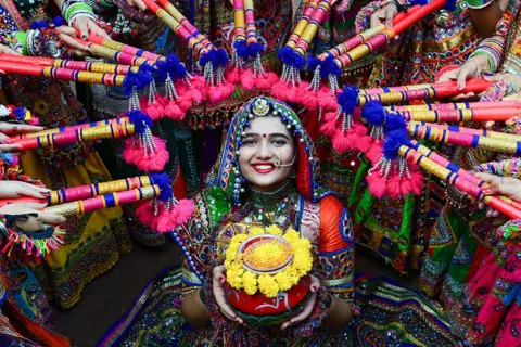 Sam Panthaky / AFP A woman prepares for the festival of Navaratri in Ahmedabad