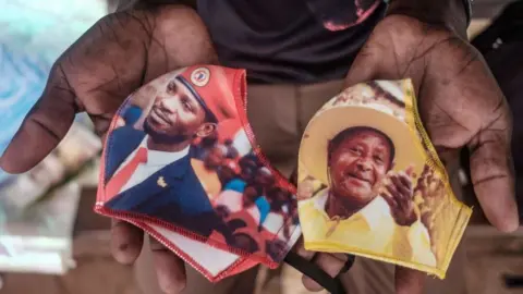 Getty Images Face masks showing presidential candidates in Uganda - Bobi Wine, left, and Yoweri Museveni, right