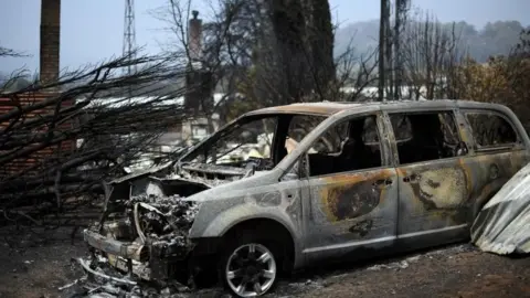 AFP/Getty Images A burnt-out car from a bushfire in New South Wales