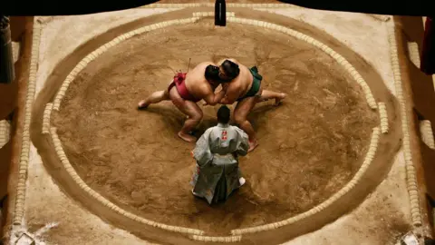 Getty Images Sumo wrestlers Miyabiyama and Takekaze of Japan grapple each other in the middle of the ring during the Grand Sumo Championship