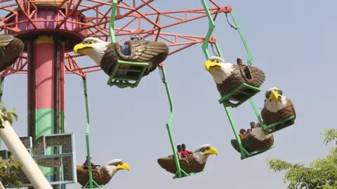 Emmanuel Osodi/Getty Images People on an amusement park ride in Abuja, Nigeria - Wednesday 10 April 2024