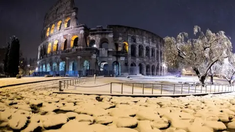 EPA The Colosseum is covered by snow during a snowfall in Rome, Italy, 26 February 2018.