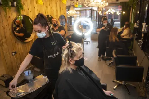 EPA A woman getting her hair cut in a salon in Belfast