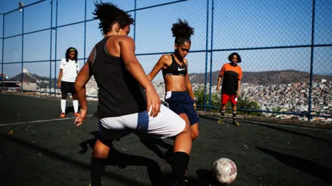 Gustavo Oliveira/WBR Photo Competitive training on the field, as one girl attempts to evade a tackle from her training partner