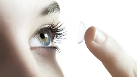 Getty Images Library image of a woman fitting a contact lens