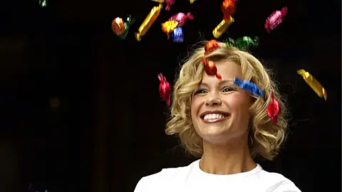 Getty Images Melinda Messenger throws chocolates in the air