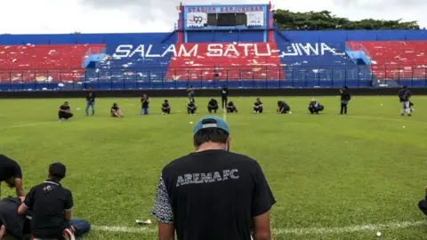 Getty Images Players grieve after the tragedy at the Kanjuruhan stadium