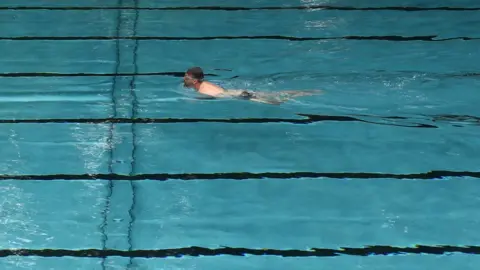 Reuters Man swimming in an empty pool