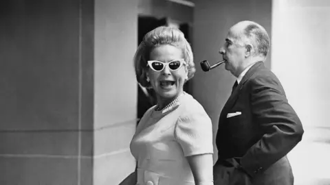 David Hume Kennerly John Mitchell, Nixon's attorney general, and his wife, Martha, walking