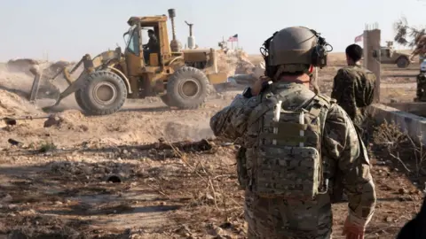 US Central Command US soldier observes SDF's destruction of military fortification at an unspecified destination in Syria on 22 August 2019