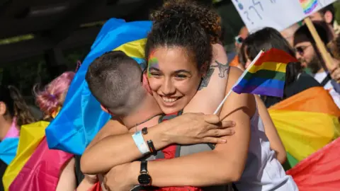 Getty Images Two marchers embrace during the Pride celebrations