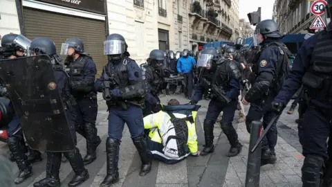 Getty Images Police apprehend one protester in Paris.