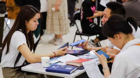 EPA-EFE/REX/Shutterstock Job seekers and recruiters at a job fair in Beijing, China.