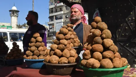 A Syrian man sells desert truffles at a market in the city of Aleppo (28 February 2024)