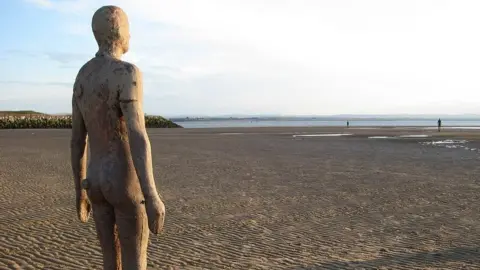 Philip Jeffrey/Geograph Iron sculpture of a man on Crosby Beach