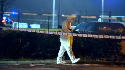 PA Media A forensics officer at the scene of a shooting in the Killyclogher Road area of Omagh