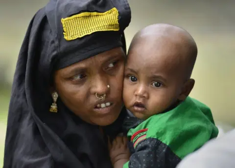 EPA A woman with her baby waits in queue to verify her name on National Register of Citizens draft in Assam on 30 July 2018.