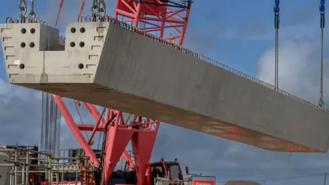 Crane lifts a large piece of viaduct into place.