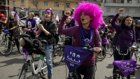 Getty Images Women wear purple as they take part in a feminist bicycle protest during International Women's Day in Madrid, Spain, 8 March 2020