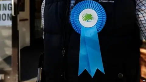 AFP Man wearing Conservative rosette