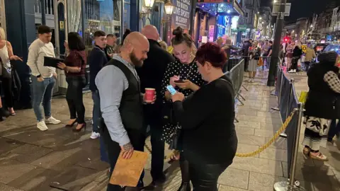 A doorman checking Covid passes