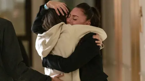 ISRAEL PRIME MINISTER'S OFFICE/handout via Reuters Moran Stela Yanai, 40, embraces her sister, Lea Yanai, following her arrival in Israel after being held hostage by the Palestinian militant group Hamas in the Gaza Strip, at Sheba Medical Center