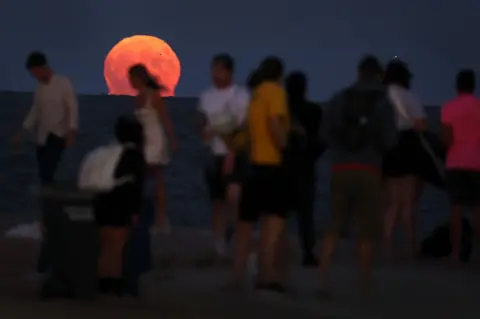 Scott Olson/Getty Images People gather along North Avenue Beach as a super blue moon rises on August 30, 2023 in Chicago, Illinois