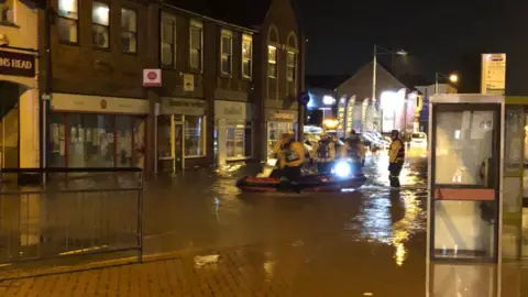 Nottinghamshire Fire and Rescue Service Firefighters on boat in flooded town centre