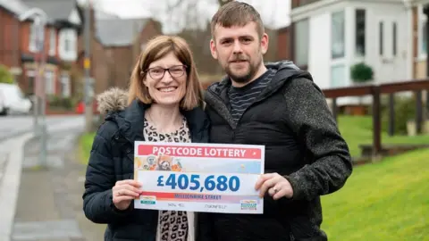 People's Postcode Lottery/PA Media Rachel Lee, 33, an NHS support worker Dukinfield, Greater Manchester, with her husband John, 37