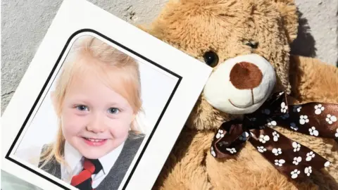 Getty Images A school picture of Alesha MacPhail is left outside the house on Ardbeg Road on Bute