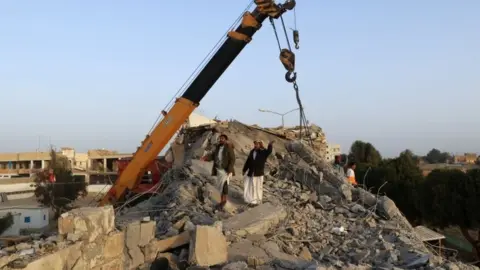 Rescuers use a crane to remove collapsed concrete at the detention centre