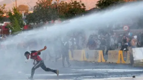 Reuters Police fire water cannon at protesters