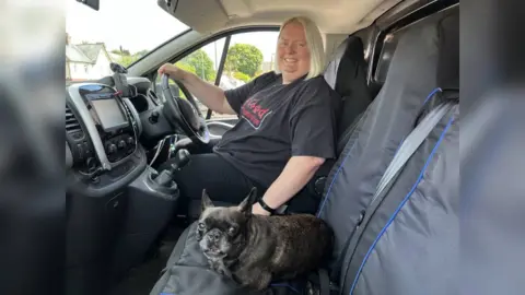 women and dog in front of a van