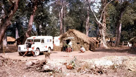 Britain Nepal Medical Trust One of the project ambulances at a health post at a temporary camp on the East-West Highway at Butwal in about 1969.