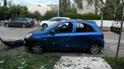 Reuters Car damaged by rocket fragments in the community of Mishmeret, central Israel (25 March 2019)
