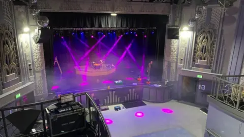 BBC Image of The Wells Picture House interior. The stage is lit up with purple spotlights