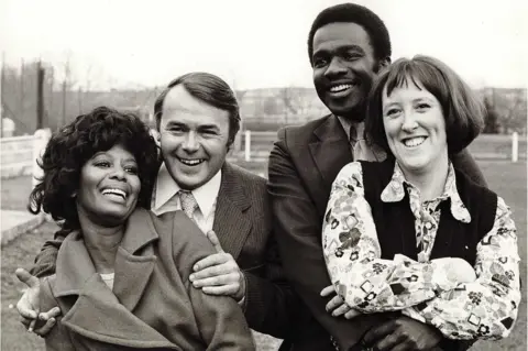 Studio Canal/Shutterstock Nina Baden-Semper, Jack Smethurst, Rudolph Walker, Kate Williams,