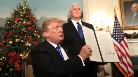 EPA US Vice-President Mike Pence watches (right), as Donald Trump holds up his proclamation on Jerusalem's policy. Photo: 6 December 2017