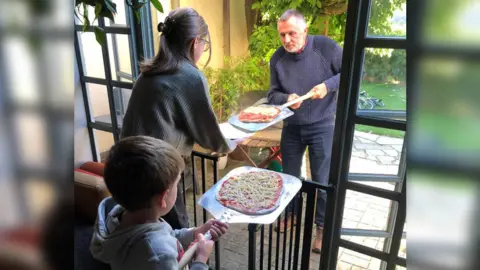 Family photo Yuliia, Matvii and Simon making homemade pizza