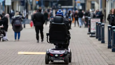 ADAM VAUGHAN/EPA-EFE/REX/Shutterstock Person riding mobility scooter in public
