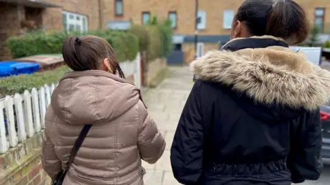 Two women walking on street