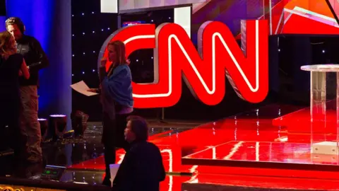 AFP The CNN glows behind staff setting up for a Republican presidential debate in December 2015