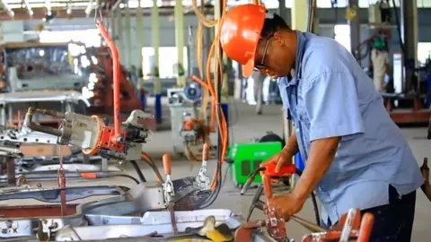 BBC A factory worker in Nigeria