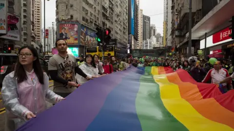 AFP Participants of Hong Kong's annual pride parade walk through the streets with a large rainbow flag on 26 November, 2016