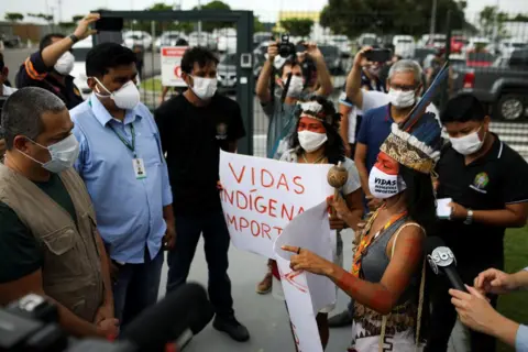 Reuters Vanderlecia talks to Robson Santos da Silva, as she takes part in a protest