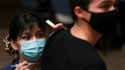 Reuters A healthcare worker prepares to vaccinate a man in Santiago, Chile. File photo