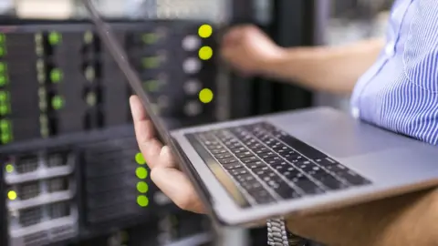 Getty Images Laptop next to a server